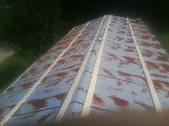 Rusted metal roof panels with new wood purlins before replacement — Storm Damage Roof Repair in Hennepin by Roofing Brothers