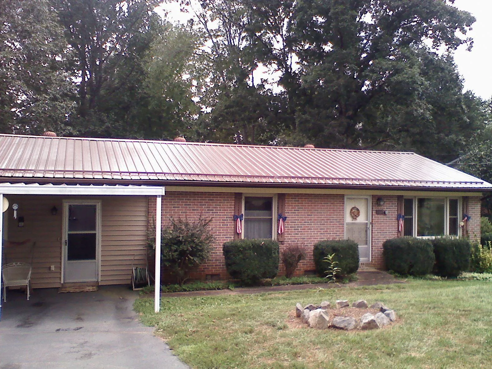 Bronze metal roof and carport on a brick ranch home — Roof Repair work by our crew in Hennepin